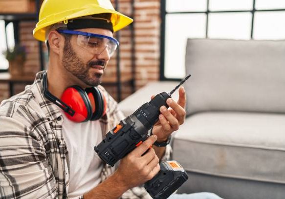Young hispanic man worker smiling confident holding drill at home Young hispanic man worker smiling confident holding drill at home